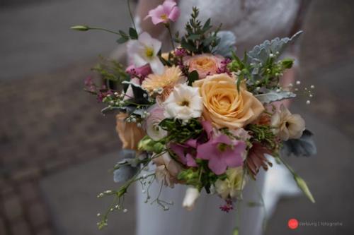 Bruidsboeket veldachtig met verschillende bloemen in kleuren volgens thema bruidspaar